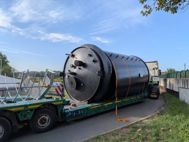 Schwarzer Drucktank auf grünem Tieflader mit Scania-Zugmaschine